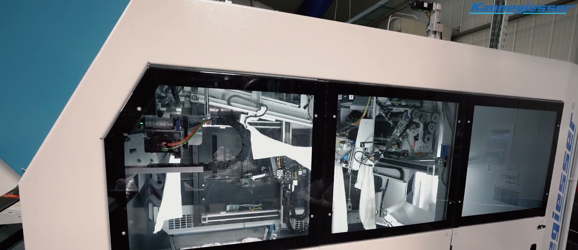A Kannegiesser automatic folding machine with glass panels on the production line