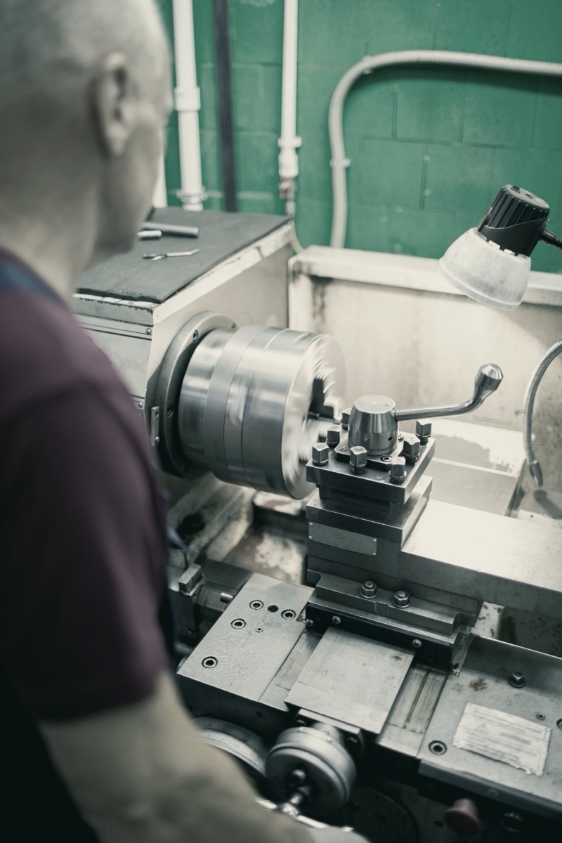 An experienced machinist running a lathe, decades of hands-on judgment worth capturing