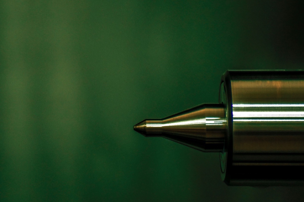 Macro close-up of a precision-machined steel part, the kind of spare part quoted from history