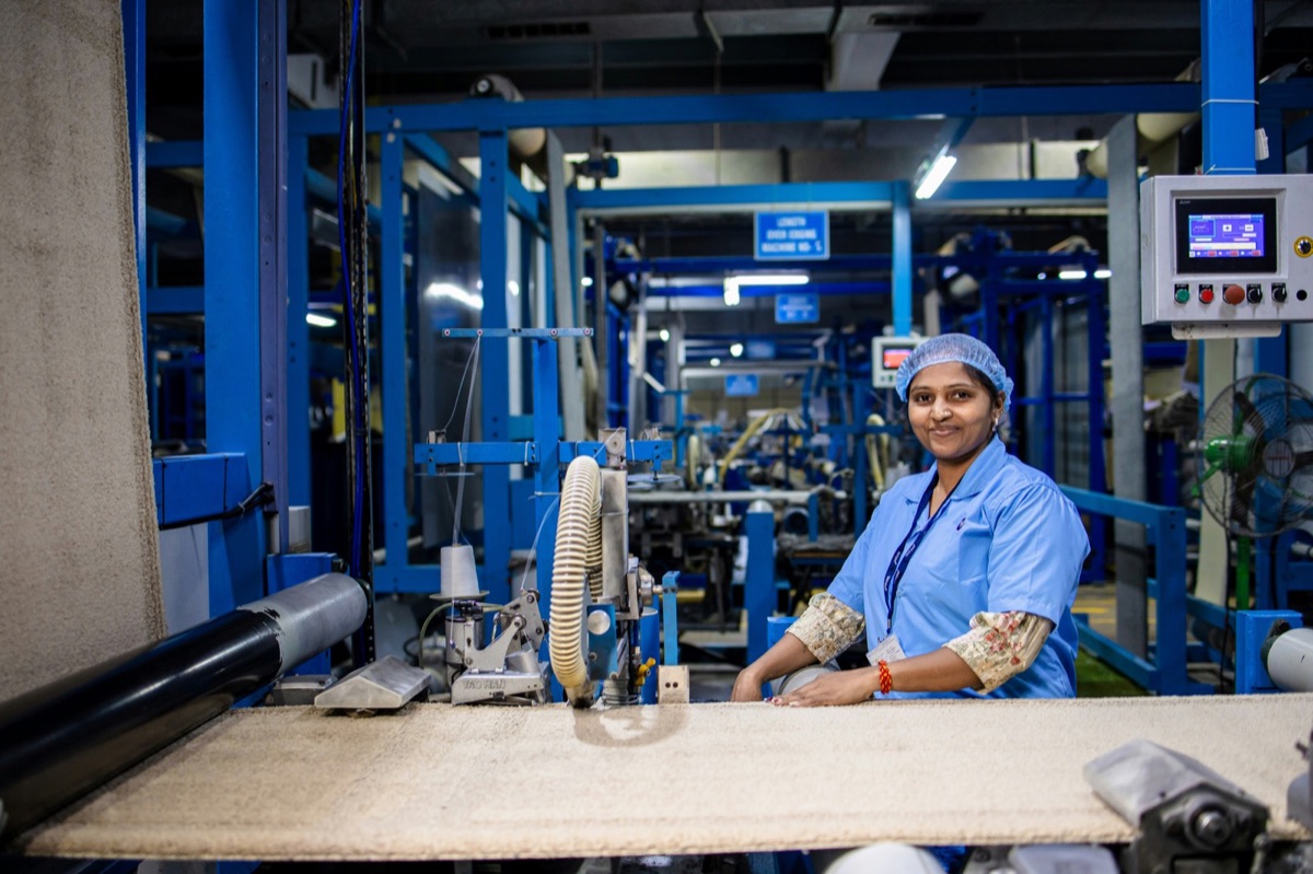 A production operator at her station beside a machine control screen, a domain expert using the tools directly